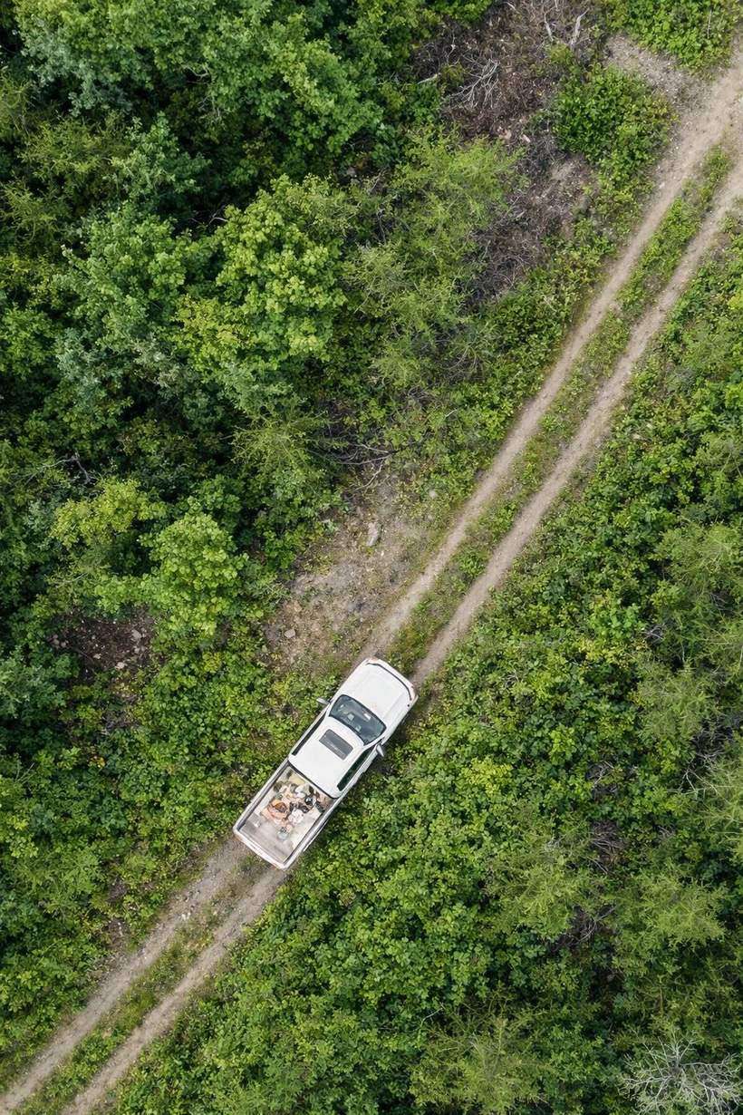 Aerial view of an exploration truck on a bush road through boreal forest