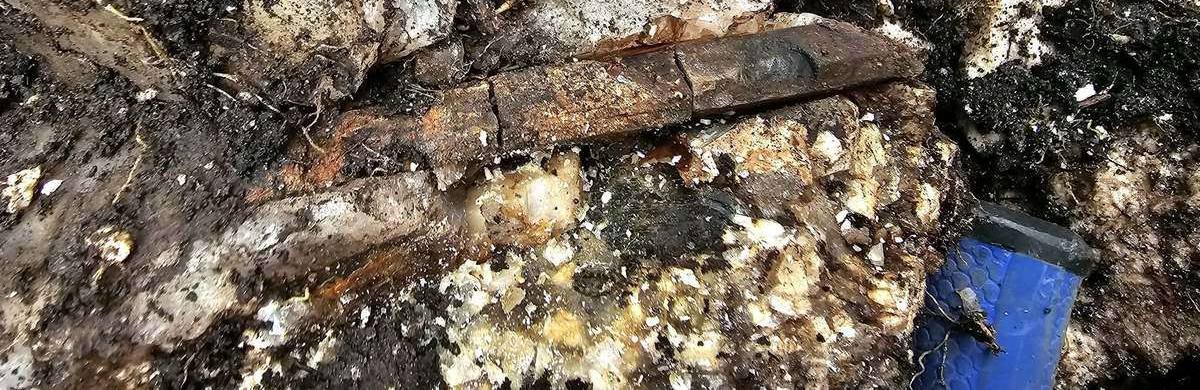 Coarse-grained quartz-rich pegmatite with a rock pick placed for scale